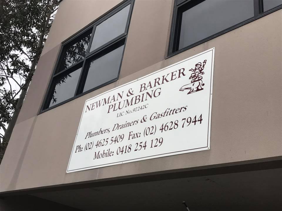 Signage for Newman and Barker Plumbing displayed outside of a building